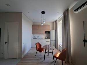a kitchen with a table and chairs in a room at Central Avenue in Karagandy