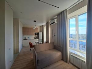 a living room with a couch and a large window at Central Avenue in Karagandy