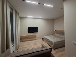 a bedroom with a bed and a flat screen tv at Central Avenue in Karagandy