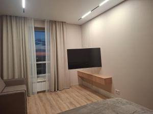 a bedroom with a flat screen tv on a wall at Central Avenue in Karagandy +7 photos