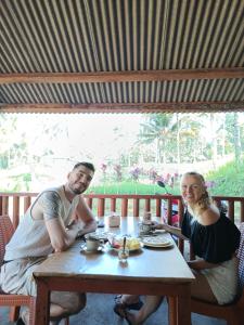 a man and a woman sitting at a table at Bunga Lodge Tetebatu in Tetebatu