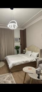 a bedroom with a large bed and a chandelier at Ksa3 in Hail