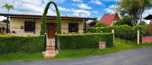 a house with a fence and a plant at Casa campestre cerca de termales con WiFi y parqueadero in Santa Rosa de Cabal
