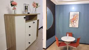 a dining room with a table and a room with blue walls at Cotonou AMAZONE GUEST in Cotonou