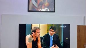 a tv screen with a picture of a man with a tattoo at Cotonou AMAZONE GUEST in Cotonou