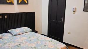 a bedroom with a bed and a black door at Cotonou AMAZONE GUEST in Cotonou +6 photos