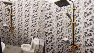 a bathroom with a toilet and a shower curtain at Cotonou AMAZONE GUEST in Cotonou
