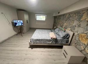 a bedroom with a bed and a stone wall at Il Bunker in Bolano