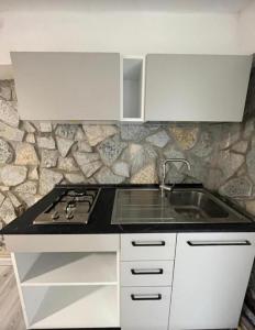 a white kitchen with a stove and a sink at Il Bunker in Bolano