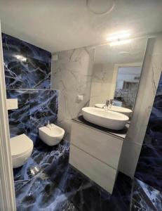 a bathroom with two sinks and two toilets at Il Bunker in Bolano