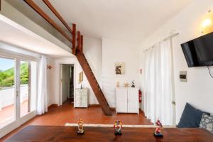 a living room with a table and a tv at Carasau 200m from the Beach - Garden - BBQ - Wi-Fi - Parking - Pet Friendly in Budoni