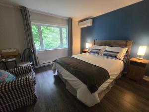 a bedroom with a large bed and a window at Rester Vivant Chambres d'hôtes in Saint-Jean-Port-Joli