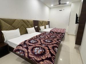 two beds in a hotel room with at Hotel U V 2 mins from golden temple in Amritsar