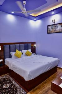 a bedroom with a large white bed with yellow pillows at Hotel Cyra palace in Jaipur +21 photos