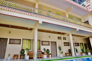 a hotel with a swimming pool in front of a building at Hotel Cyra palace in Jaipur