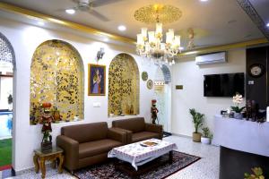 a living room with a couch and a chandelier at Hotel Cyra palace in Jaipur