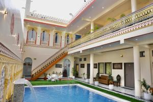 a large building with a swimming pool and stairs at Hotel Cyra palace in Jaipur
