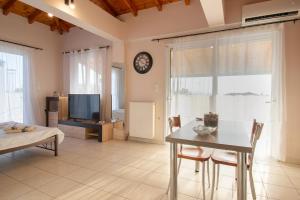 un soggiorno con un tavolo e un orologio a muro di SkyView Loft a Kalamáta