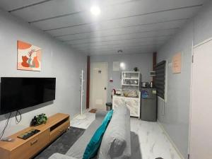 a living room with a couch and a flat screen tv at Kecai Haven Transient House in Digos