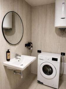 a bathroom with a washing machine and a sink at Emera Apartments in Vlorë +192 photos