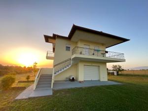 a house with a sunset in the background at Olyvia in Plaka Litochorou