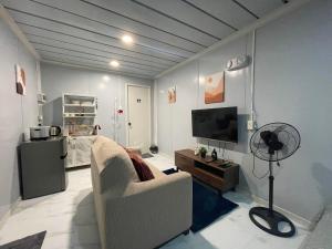 a living room with a couch and a flat screen tv at Kecai Haven Transient House in Digos