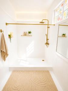 a white bathroom with a tub and a window at Cocoon Signature in Flic-en-Flac +40 photos