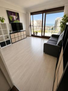 a living room with a couch and a television at Modern Studio with Sea View and Balcony in Middelkerke
