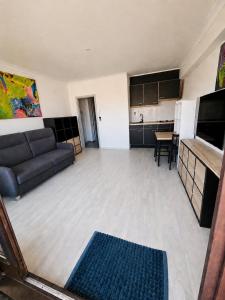 a large living room with a couch and a kitchen at Modern Studio with Sea View and Balcony in Middelkerke