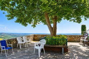 a group of chairs and a tree on a patio at Charmant appartement climatisé en plein coeur du village et proche des plages avec wifi in Cervione
