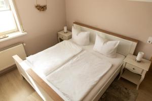 a white bed with white sheets and pillows in a bedroom at Ferienwohnung Doria in Windeck