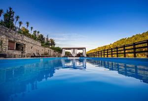 a large swimming pool with blue water and a gate at Paxos Santa Marina Villas in Gaios