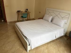 a bedroom with a large bed with white sheets and a table at Neoclassical apartment downtown in Casablanca