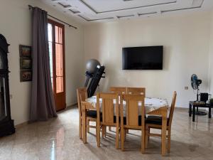 a dining room with a table and chairs and a television at Neoclassical apartment downtown in Casablanca