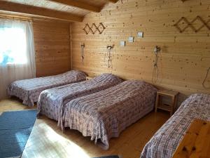 a room with three beds in a log cabin at Voosemetsa Turismitalu in Voose
