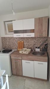 a kitchen with white cabinets and a sink at Coco 2 free parking in Pržno