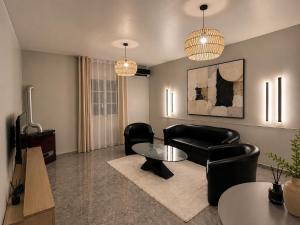 a living room with black leather chairs and a table at Maison élégance in Tizi Ouzou