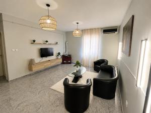 a living room with black chairs and a television at Maison élégance in Tizi Ouzou +5 photos