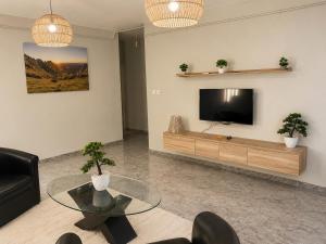 a living room with a tv and a glass table at Maison élégance in Tizi Ouzou