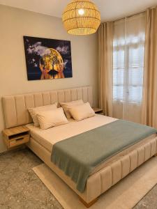 a bedroom with a large bed and a chandelier at Maison élégance in Tizi Ouzou