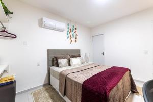 a bedroom with a bed in a white room at Apartamentos com internet rápida in Maceió