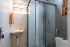 a bathroom with a glass shower and a sink at Apartamentos com internet rápida in Maceió +31 photos
