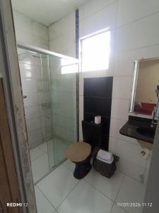 a bathroom with a shower and a toilet and a sink at kit Net no Vinhais in São Luís