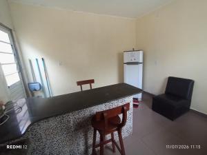 a kitchen with a counter and a chair and a refrigerator at kit Net no Vinhais in São Luís