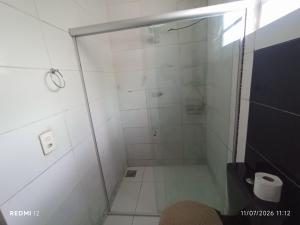 a shower with a glass door in a bathroom at kit Net no Vinhais in São Luís +1 photo