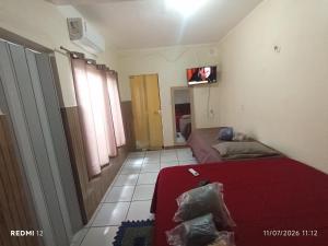 a room with two beds and a tv on the wall at kit Net no Vinhais in São Luís