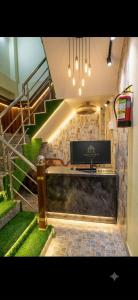 a room with a staircase and a desk with a television at Elora Hotel in Ujjain +4 photos
