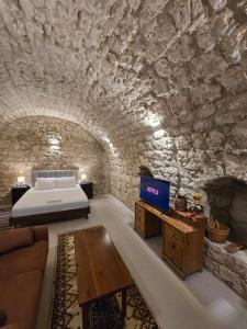 a bedroom in a cave with a bed and a couch at Estia Mylona in Ayios Therapon