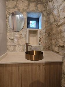 a bathroom with a sink and a stone wall at Estia Mylona in Ayios Therapon