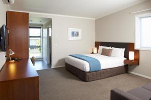 a hotel room with a bed and a television at Argent Motor Lodge in Hamilton